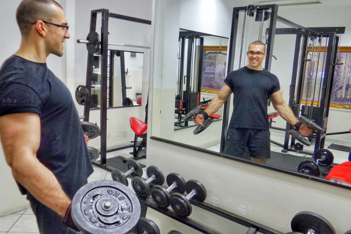 person at a gym looking at a wall mirror