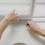 person showing how to measure a window for replacement